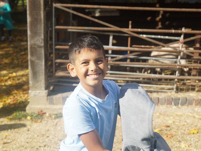 Boy holding a hoody smiling at the camera