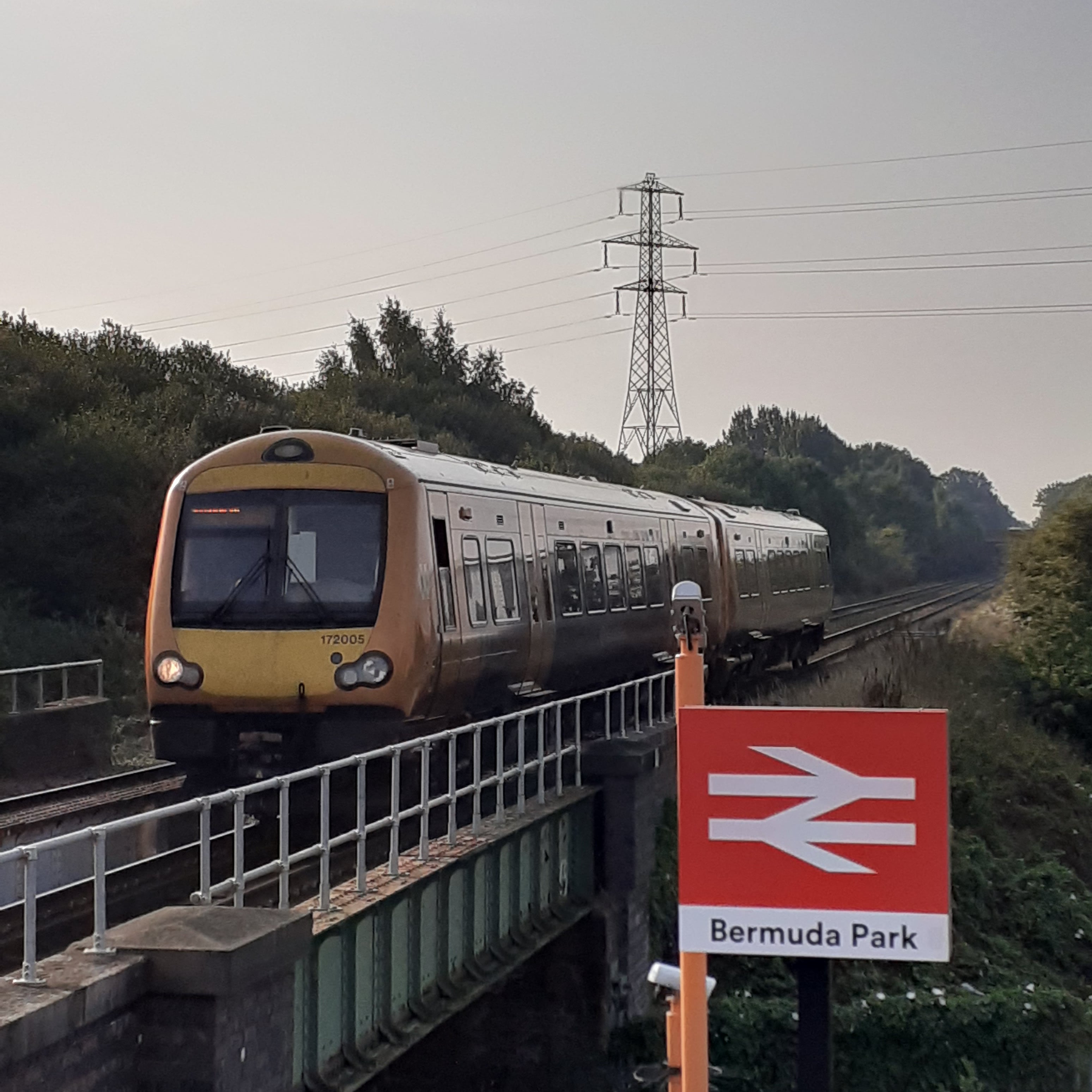 Train arriving at a station with the sign 'Bermuda Park'